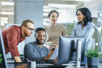 Business professionals reviewing work at computer