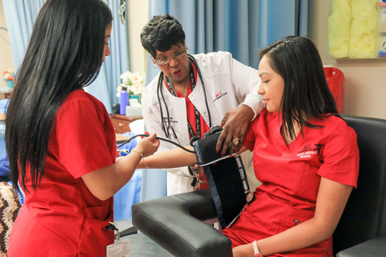 Students and teacher training how to take blood pressure