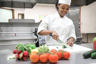 Culinary student cutting fruits and vegetables