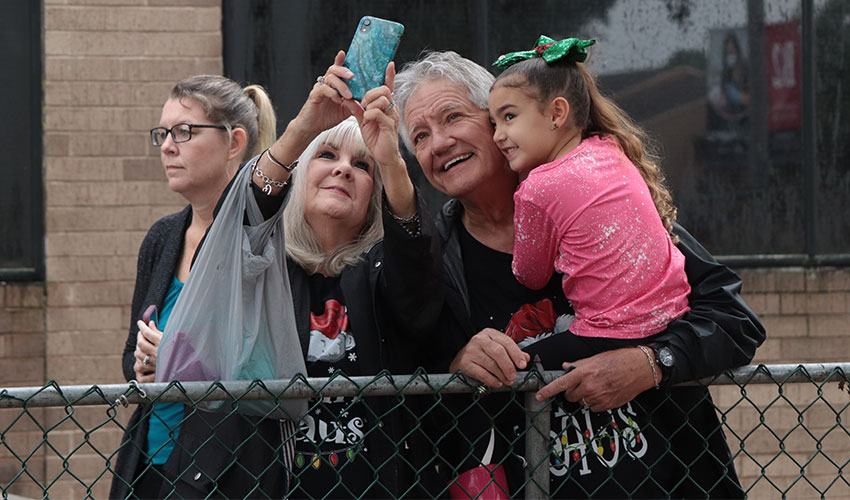 A little girl taking a selfie with her grandparents