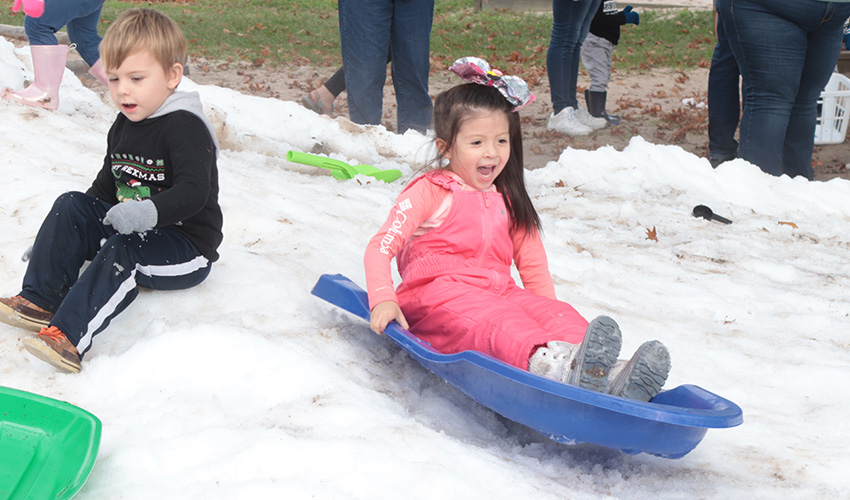 Girl sliding down the snow hill