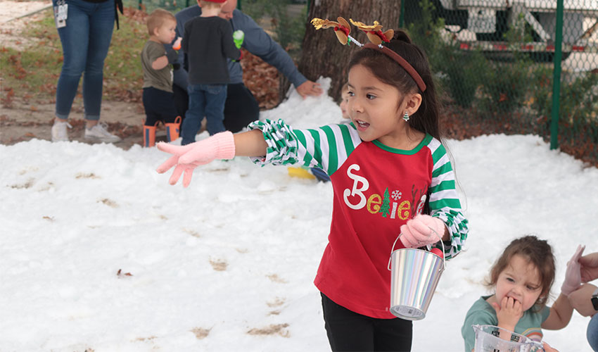 Little girl playing with the snow