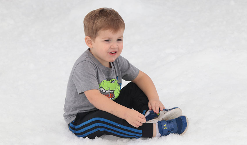 Little boy sitting on the snow