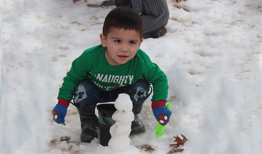 Little boy making a snow man