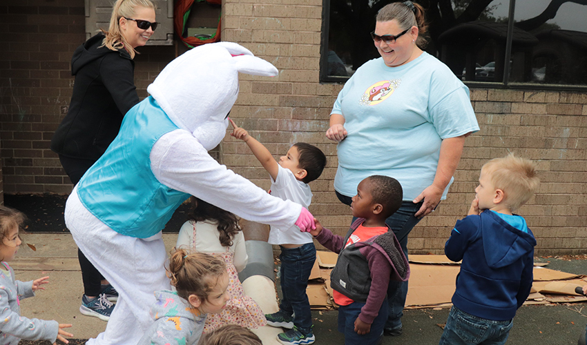 Mr. Bunny shaking little kids' hands.