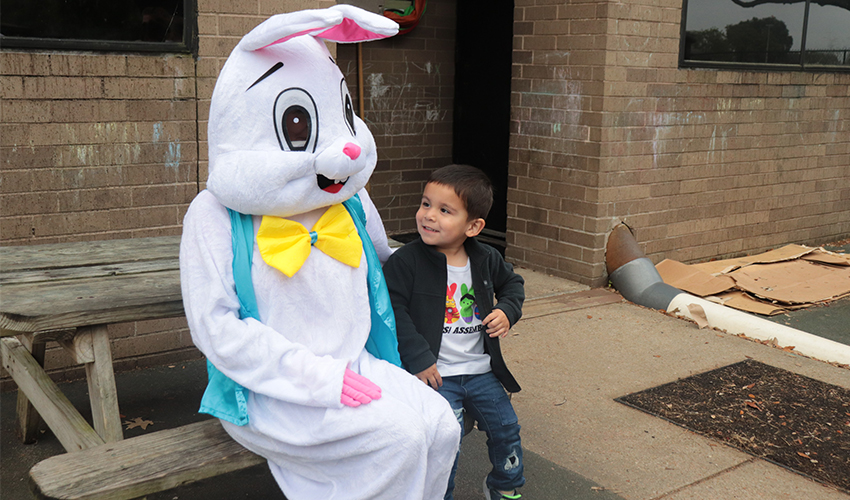 Mr. Bunny taking a picture with a little boy.