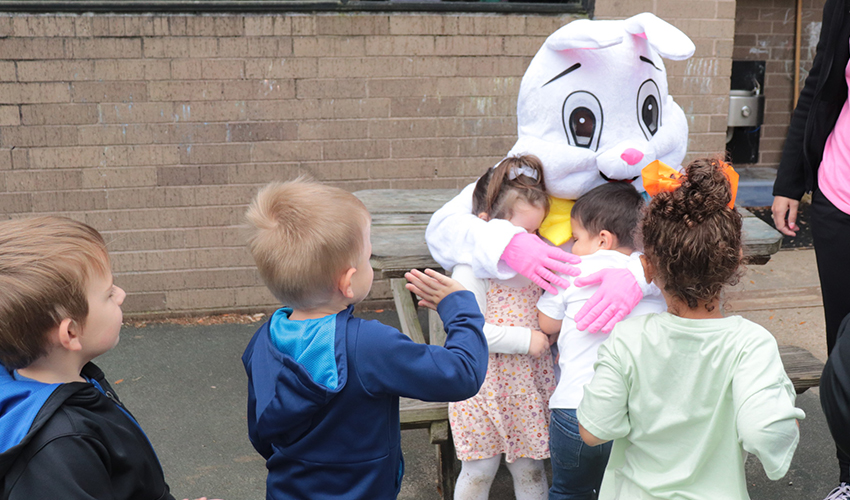 Kids hugging Mr. Bunny.