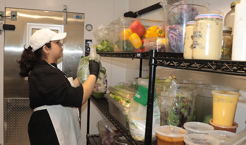 Culinary Arts student looking for vegetables in the fridge.