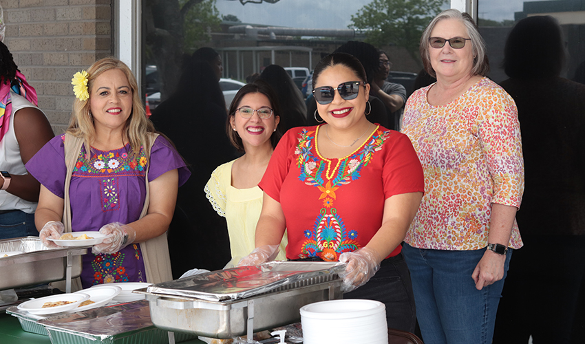 Hard-working staff serving students food. 
