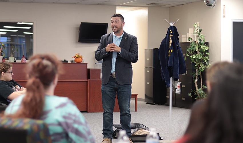 Tyler Froberg standing in front of the audience giving his presentation.