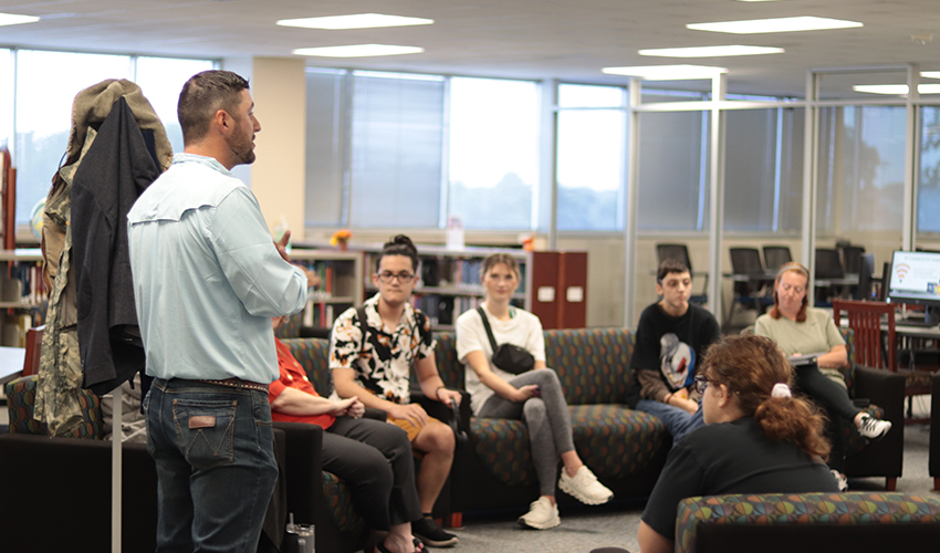 Tyler Froberg standing in front of the audience giving his presentation.