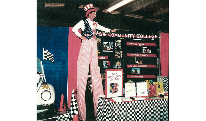 26 of 34 Stilt walker dressed in July 4th attire standing at ACC booth.